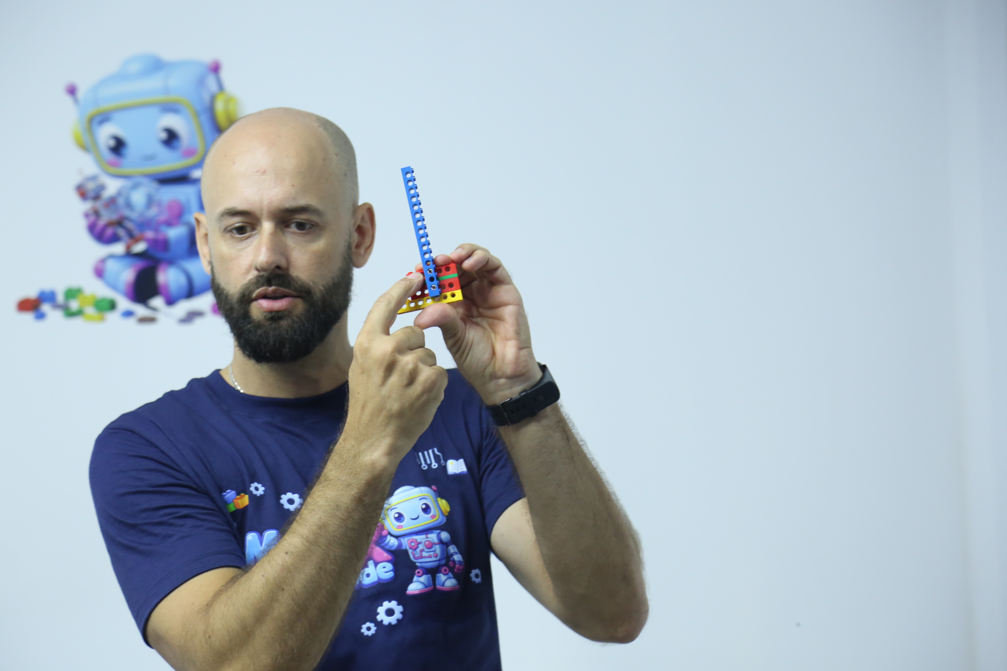 Professor demonstrando uma montagem com peças de robótica